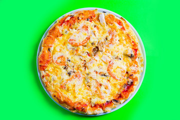 hot tasty fresh pizza on a plate close-up. green background