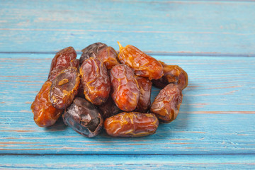 Dried dates fruit on blue wooden background