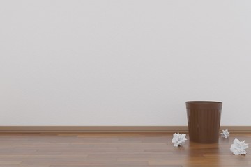Trash can and crumpled papers in the neat room