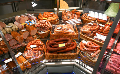 Refrigerated display case with fresh sausages in supermarket
