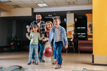 Family playing bowling in club - obrazy, fototapety, plakaty
