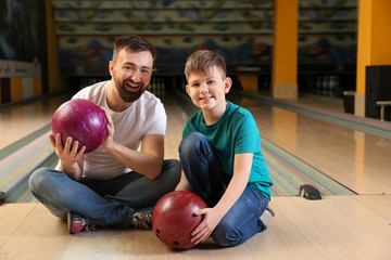 Fototapeta premium Man and his little son in bowling club