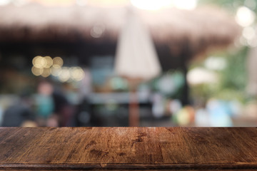 Empty dark wooden table in front of abstract blurred bokeh background of restaurant . can be used for display or montage your products.Mock up for space.