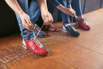 Family changing shoes before playing bowling in club