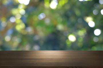 Image of wooden table in front of abstract blurred background of outdoor garden lights. can be used for display or montage your products.Mock up for display of product.
