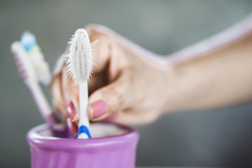 woman hand using old and destroy toothbrush closeup  