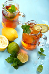Iced tea with lemons, limes and mint with ice cubes, summer refreshment drink