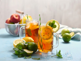 Iced tea with lemons, limes and mint with ice cubes, summer refreshment drink