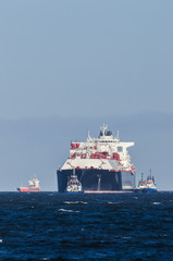 LNG TANKER - A large ship belayed by tugboats travels by water to the port © Wojciech Wrzesień