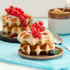 Breakfast with belgian waffles with honey caramel sauce and summer berries