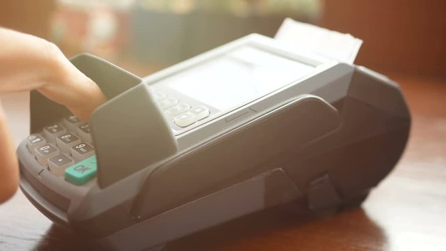 4K footage. man holding credit card in hand , swipe card at credit card terminal reader machine and use finger press password for security for purchase or shopping at shop 