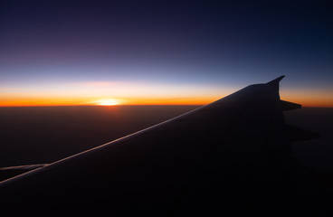 Sunset time Above the clouds.Wing aircraft in the sky