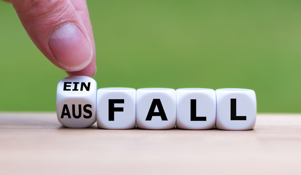 Hand dreht einen W&uuml;rfel und &auml;ndert das Wort "Ausfall" in "Einfall".