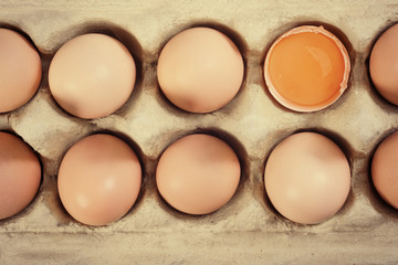 Closeup of fresh brown eggs in carton tray. Top view, tinted photo