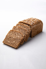 Bread with a mold, dark bread with seeds on a white background.