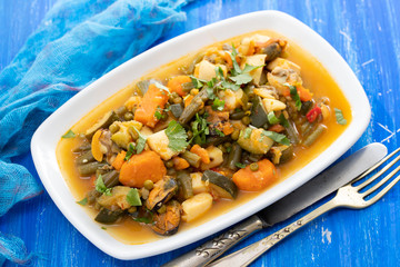 seafood with vegetables and herbs on white dish