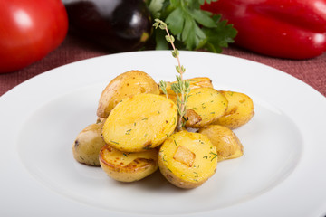 Baked yellow potatoes as garnish served with thyme