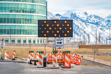 Keep Right sign underneath an arrow board surrounded by road safety poles