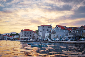 Fototapeta premium Beautiful sunset landscape. Fishing boat moored on Kastel coast in Dalmatia,Croatia.Old town near Adriatic sea.