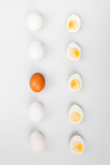 Group of raw eggs white and brown. Concept of diversity, isolation, racism, inequality. On gray background. Top view
