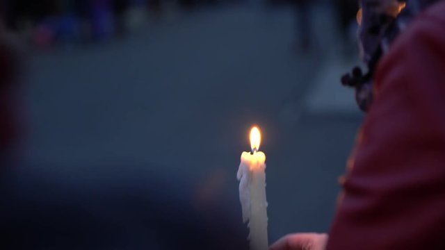 Candle burning at vigil with more candles in the background