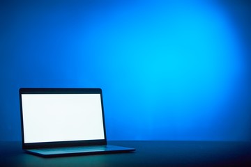 A laptop with white space for text on a blue aesthetic background