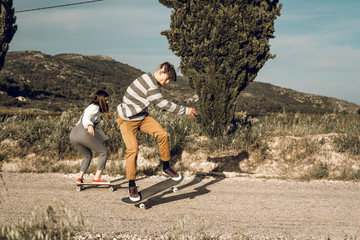 Millennial young couple having fun with a skateboard