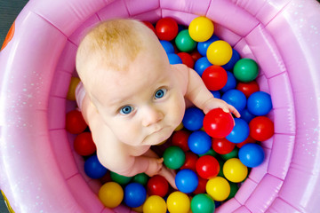 Fototapeta na wymiar baby boy playing in ball pit. top view