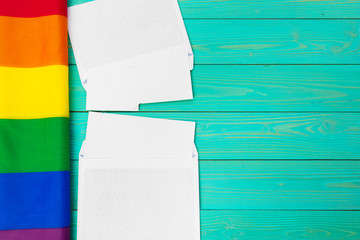 Bright rainbow gay flag on wooden background and blank space