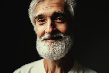 Studio portrait of handsome senior man with gray beard.