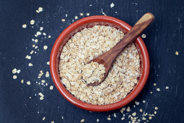 dry oats with spoon in ceramic bowl