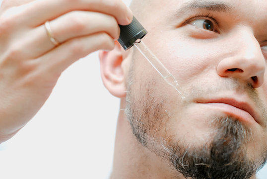 Handsome Man With Pipette With Beard Oil