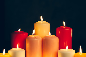 candles burning in darkness over black background. commemoration concept.