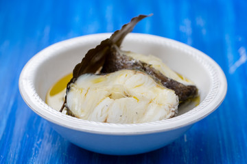 boiled fish with olive oil  and bay leaf in white dish