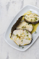 boiled fish with olive oil  and bay leaf in white dish