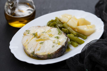 boiled fish with green beans and boiled potato on white dish