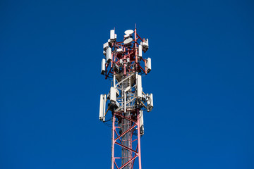 A fragment of a cell tower close-up against the blue sky.Modern telecommunication equipment.4G...