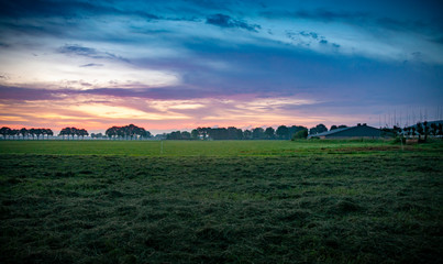 Fototapeta na wymiar Colorful sunrise, typical Dutch agricultural landscape