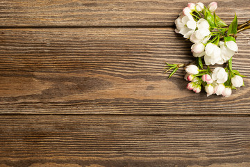 Obraz premium Flowering apple tree branch on wooden background. Spring concept. Flat layout. View from above. Copy space.