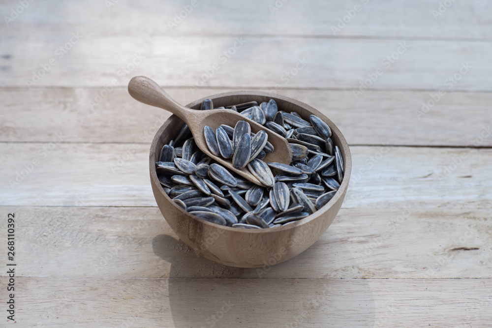 Wall mural Sunflower seed, snack, in wooden bowl on wood table