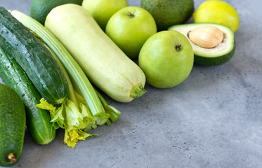 fruits and vegetables on grey background, apples, cucumbers ,zucchini, avocado, lime, celery