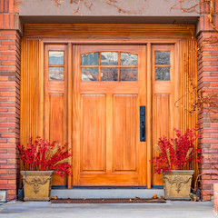 Fototapeta na wymiar Clear Square Brown wooden front door with decorative glass panels at the entrance of a home