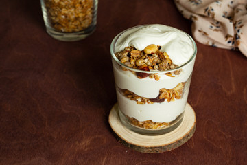Healthy breakfast with granola and homemade yogurt in a glass. Rustic style	