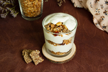 Healthy breakfast with granola and homemade yogurt in a glass. Rustic style	