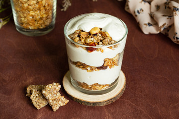Healthy breakfast with granola and homemade yogurt in a glass. Rustic style	