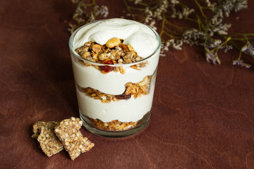 Healthy breakfast with granola and homemade yogurt in a glass. Rustic style	