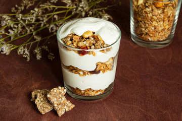 Healthy breakfast with granola and homemade yogurt in a glass. Rustic style	