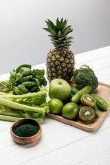 tasty fresh fruits near organic and raw vegetables on grey