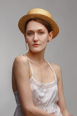 Portrait of a young attractive girl in a straw hat.