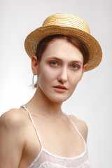 Portrait of a young attractive girl in a straw hat.